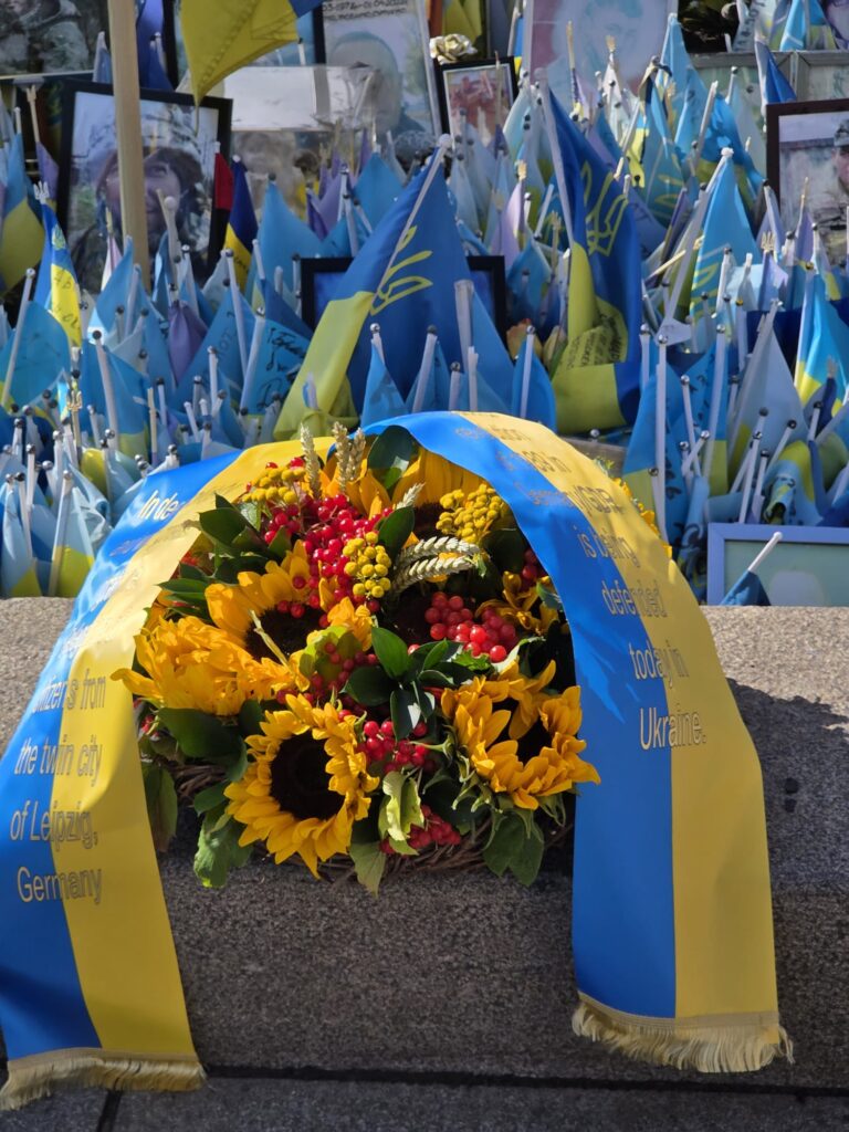 Kranz vor ukrainischen Flaggen.